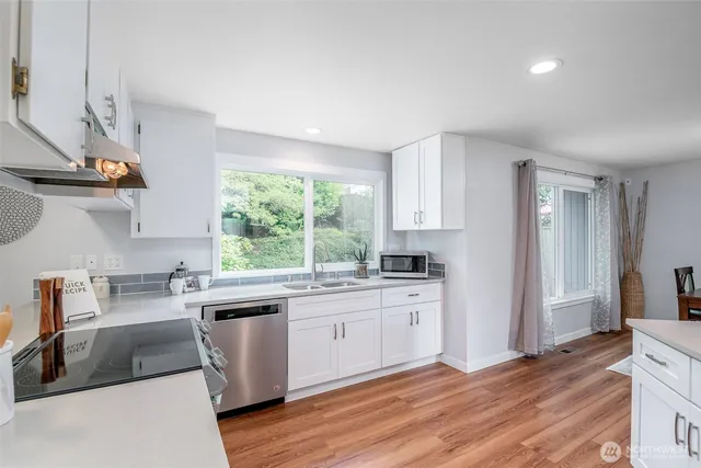 a kitchen with stainless steel appliances granite countertop a sink a stove and a refrigerator