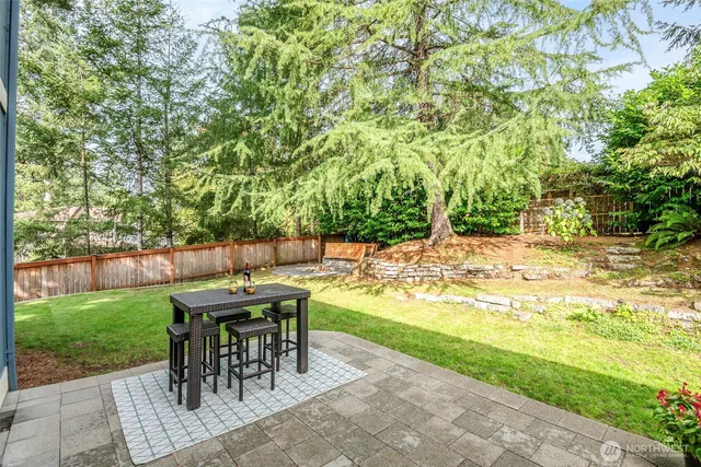 a view of a patio with table and chairs potted plants with wooden floor and fence