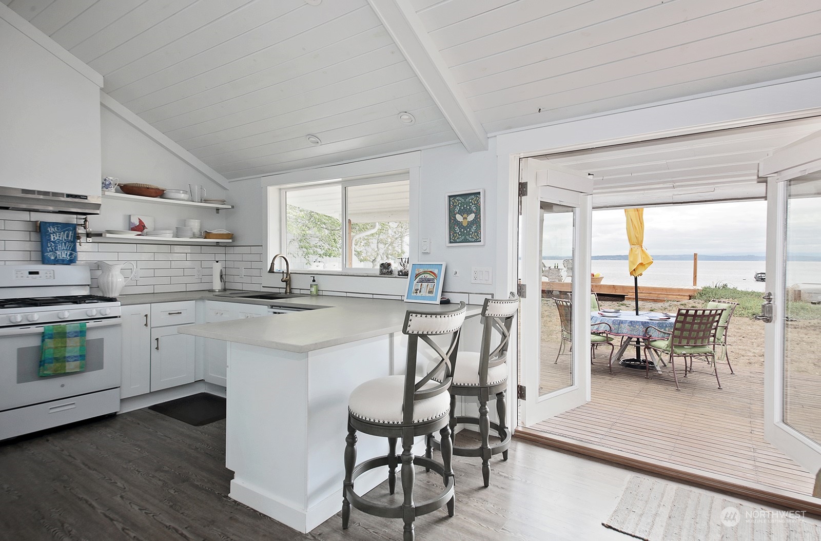 5818 Mutiny Bay Road Freeland, WA 98249 - Photo 17 of 40 a kitchen with white cabinets and dining table chair