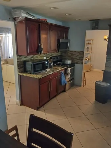 a kitchen with stainless steel appliances a stove a sink a microwave and a refrigerator