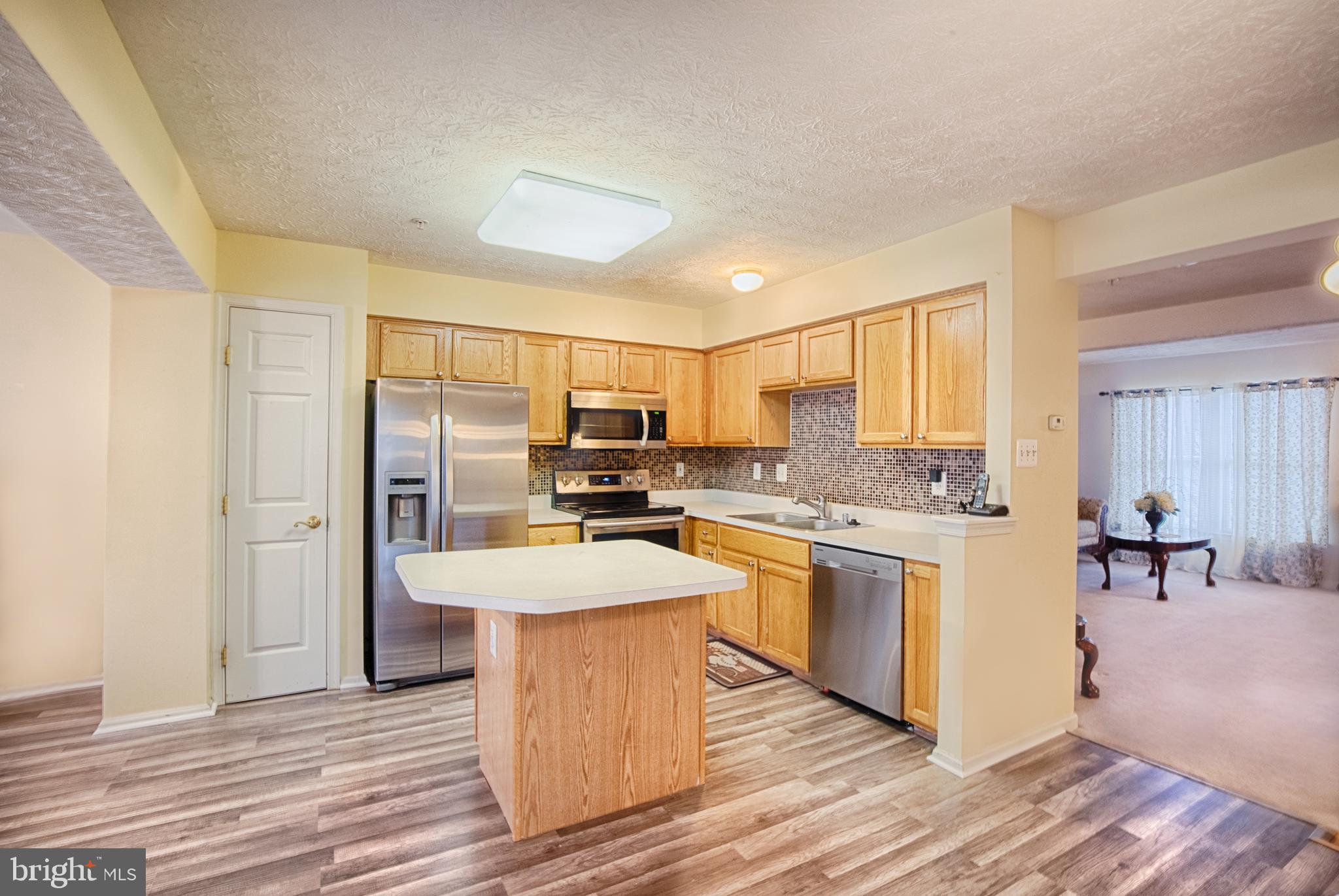 5034 Finsbury Road Baltimore, MD 21237 - Photo 4 of 23 New flooring extends through kit w island!