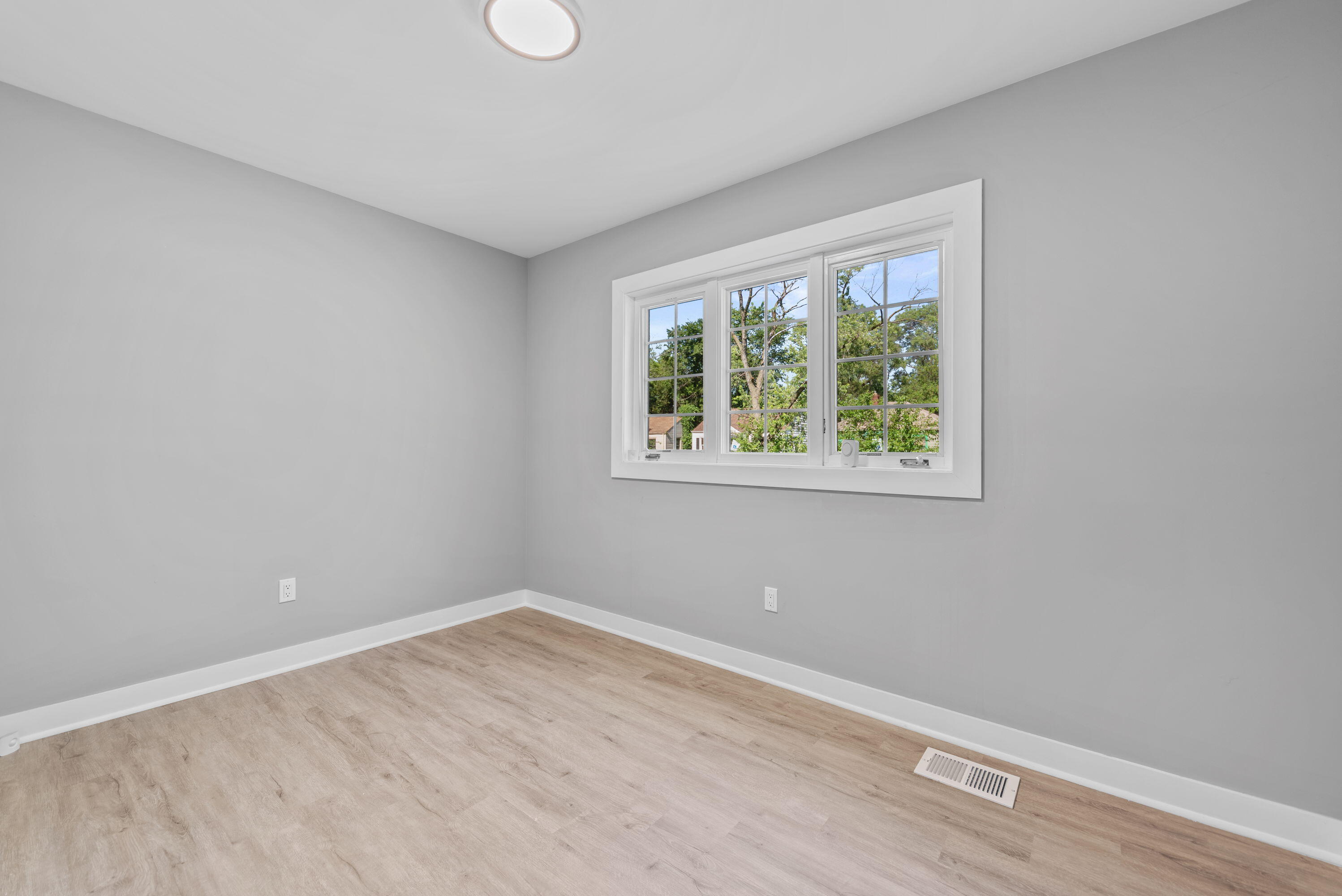 864 Ohio Street Gary, IN 46402 - Photo 9 of 27 a view of an empty room with wooden floor and a window