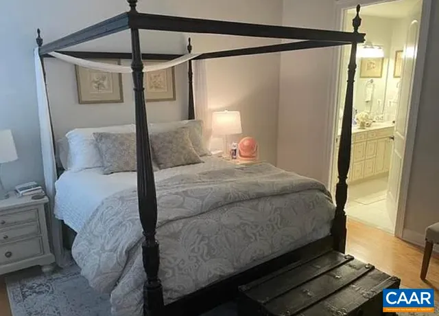 a bedroom with a bed and painting on the wall