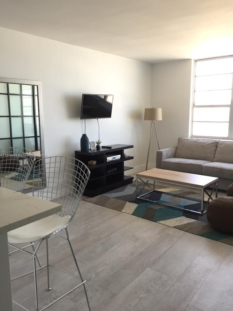100 Lincoln Road, Unit 1225 Miami Beach, FL 33139 - Photo 4 of 10 a living room with furniture and a lamp