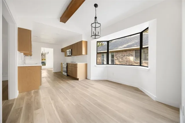 a view of empty room with wooden floor and fireplace