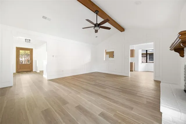 a view of a livingroom with wooden floor and a ceiling fan