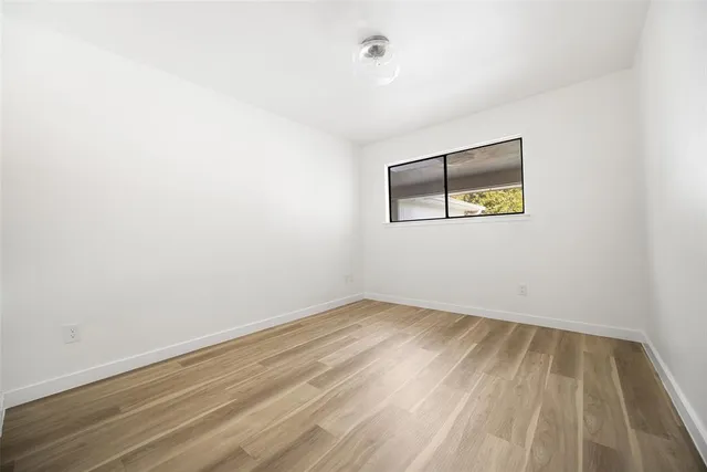 an empty room with a bench and a window