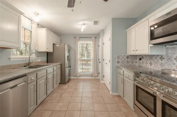 a large kitchen with a stove top oven a sink dishwasher and a refrigerator