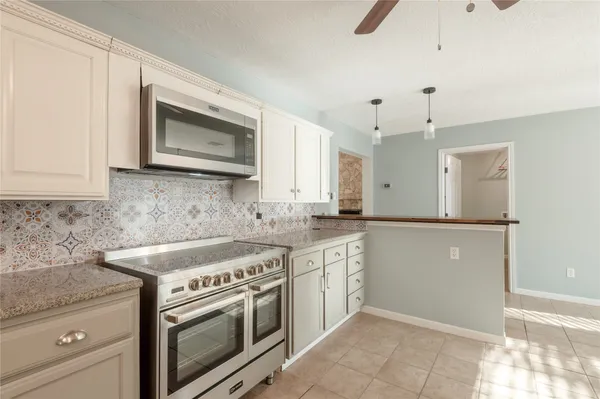 a kitchen with granite countertop a stove sink and cabinets