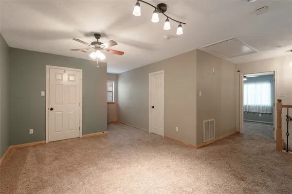 a view of an empty room with a ceiling fan