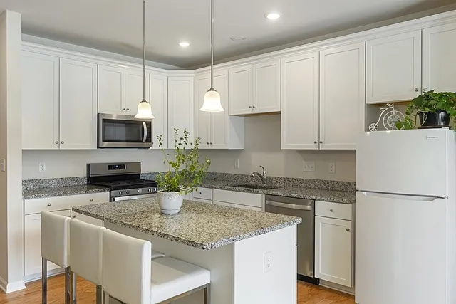 a kitchen with stainless steel appliances granite countertop a sink a stove and a refrigerator