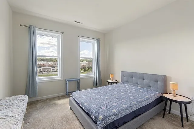 a bedroom with a bed table and window