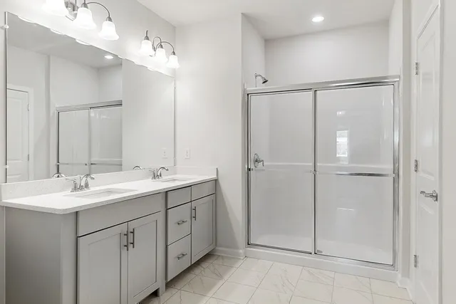 a bathroom with a double vanity sink mirror and shower