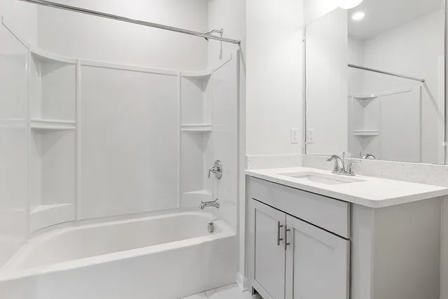 a bathroom with a granite countertop sink mirror toilet and bathtub