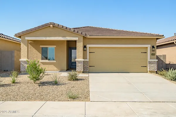 a kitchen with stainless steel appliances granite countertop a stove top oven a sink dishwasher a refrigerator and a dining table with wooden floor