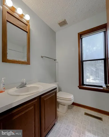 a bathroom with a toilet a sink a vanity and mirror