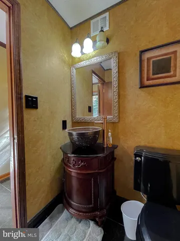 a bathroom with a toilet a sink and mirror
