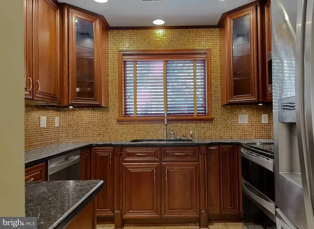 a kitchen with granite countertop stainless steel appliances and wooden cabinets