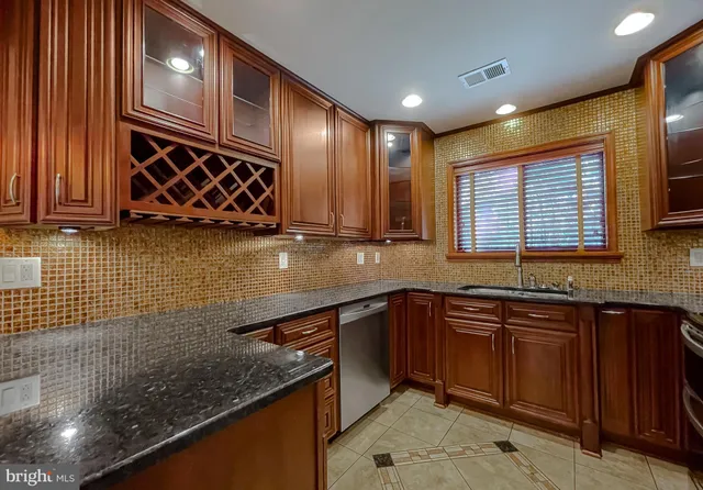 a kitchen with stainless steel appliances granite countertop a sink stove and cabinets