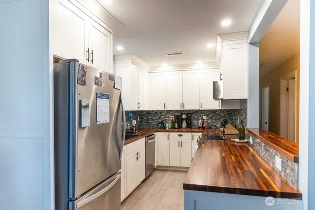 a kitchen with stainless steel appliances granite countertop a refrigerator and a sink