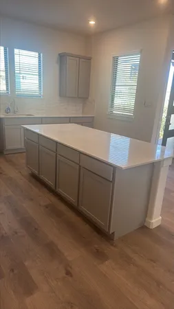 a view of a kitchen with a sink cabinets and wooden floor