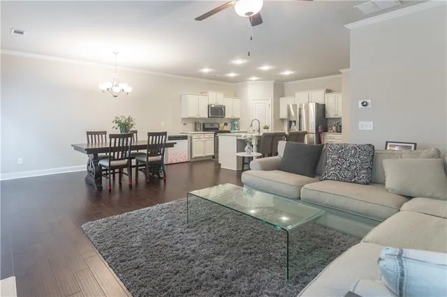a living room with furniture and a dining table with kitchen view