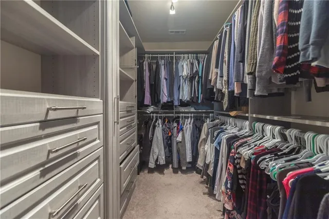 a view of walk in closet with clothes and shoes
