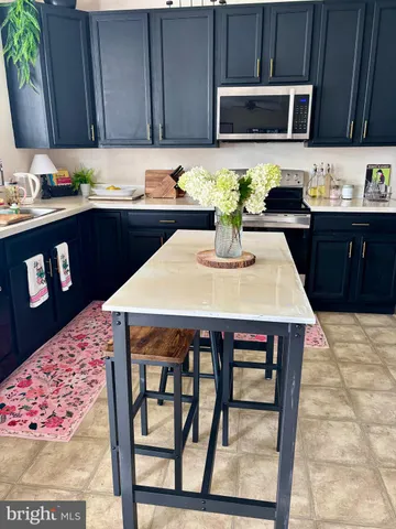 a kitchen with stainless steel appliances a sink a microwave cabinets and a counter top space