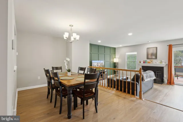 a view of a dining room and livingroom with furniture wooden floor a chandelier