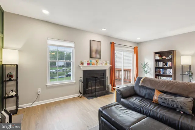 a living room with furniture and a dining table with wooden floor