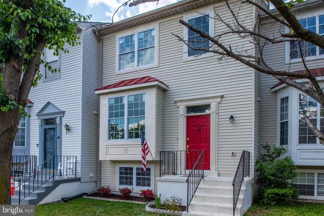 a view of a house with a yard and large tree