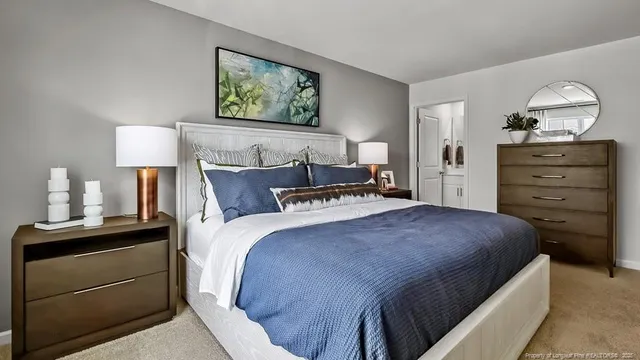 a bedroom with a bed and a lamp on dresser