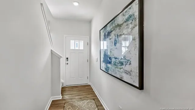 a view of a hallway with wooden floor and a large mirror