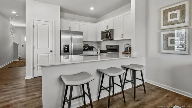 a kitchen with stainless steel appliances a dining table chairs microwave and sink