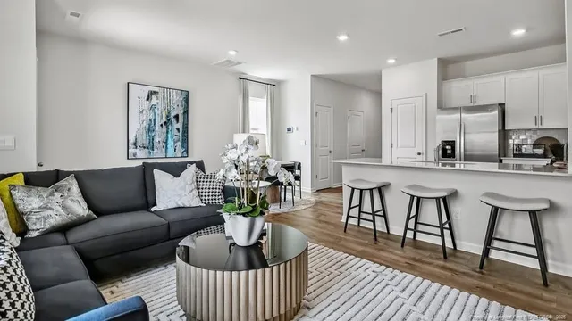 a living room with furniture and a dining table with kitchen view