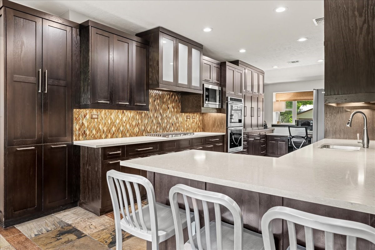 1502 Reimer Street Brenham, TX 77833 - Photo 10 of 30 a kitchen with stainless steel appliances granite countertop a table chairs sink and cabinets