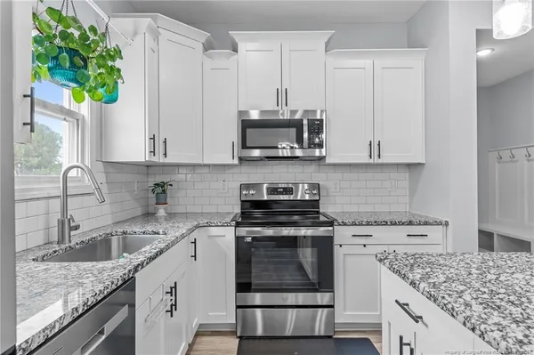 a kitchen with stainless steel appliances granite countertop a sink stove and cabinets