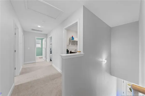 a view of a hallway to a livingroom with wooden furniture