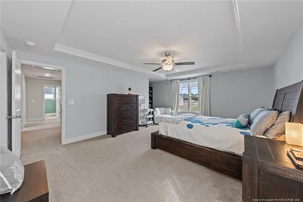 a spacious bedroom with a bed and ceiling fan