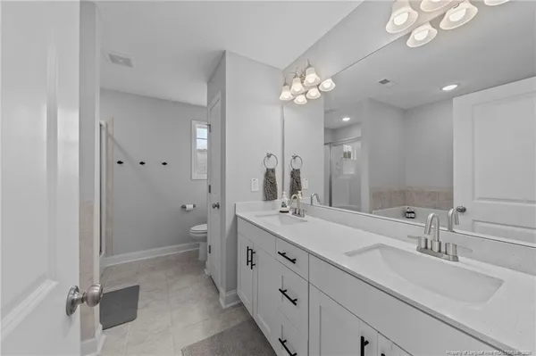 a spacious bathroom with a double vanity sink mirror and a shower