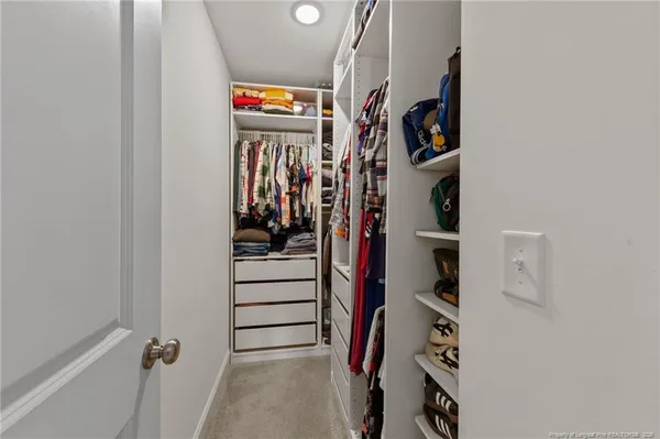 walk in closet with clothes and shoes