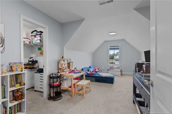 a bedroom with furniture a rug toys and a window
