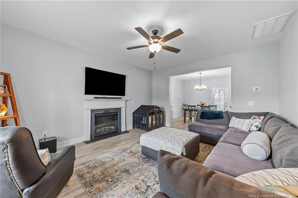 a living room with furniture a fireplace and a flat screen tv