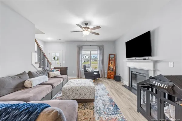 a living room with furniture a fireplace and a flat screen tv