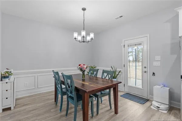 a view of a dining room with furniture wooden floor and a chandelier