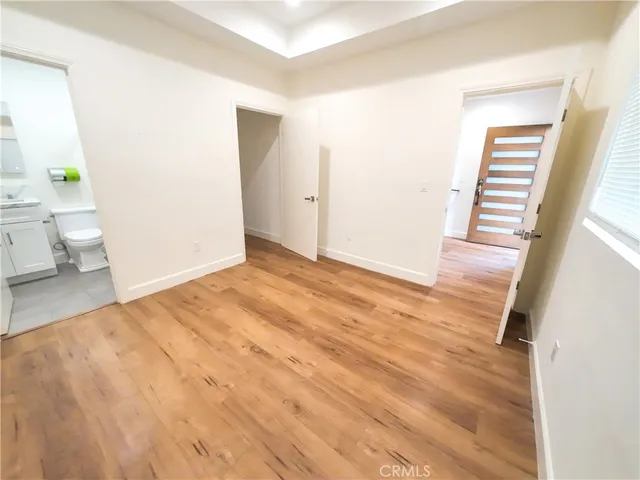 a view of a room with wooden floor and a potted plant
