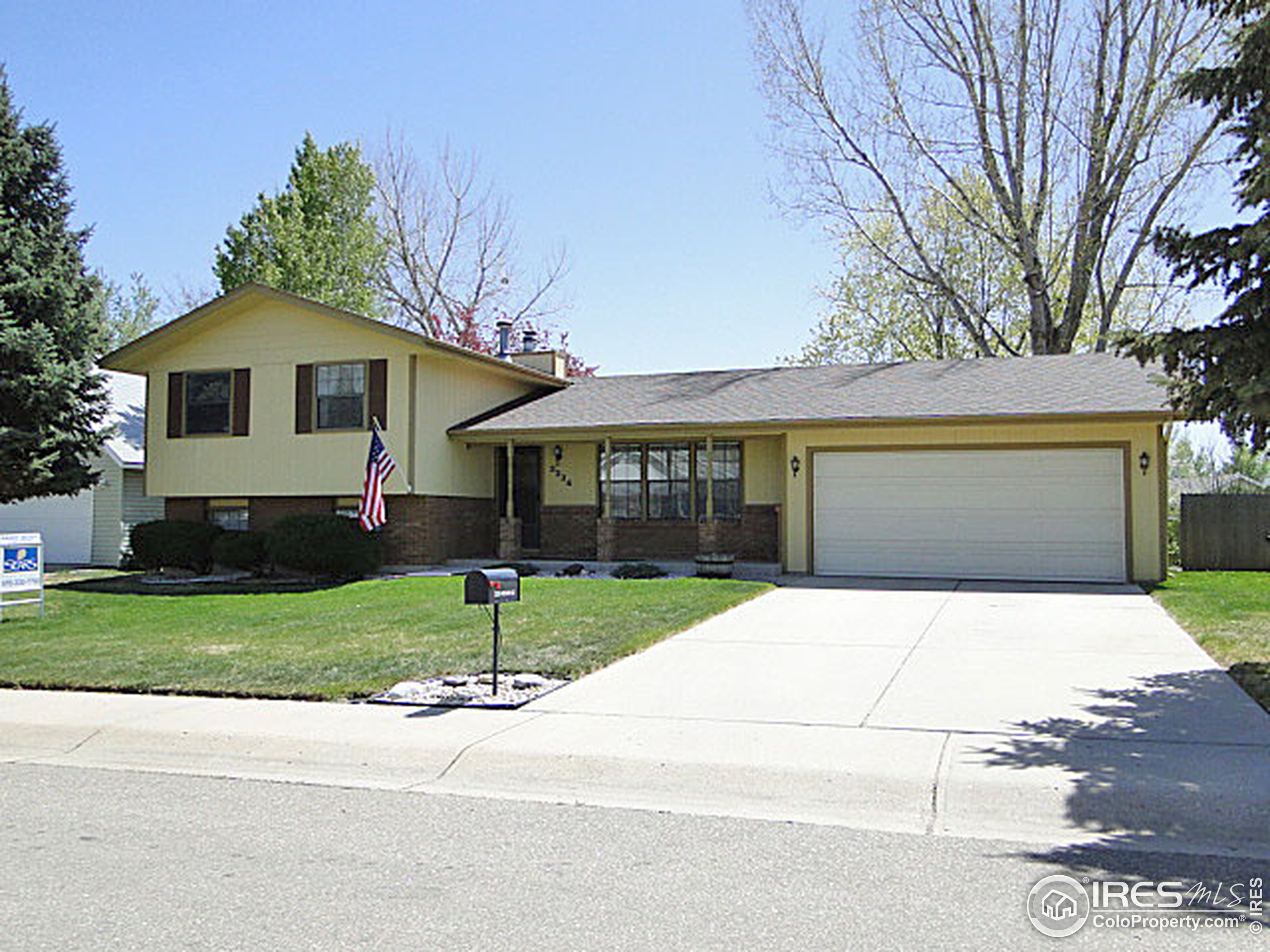 3334 34th Street Greeley, CO 80634 - Photo 1 of 25 a front view of a house with a garden and garage