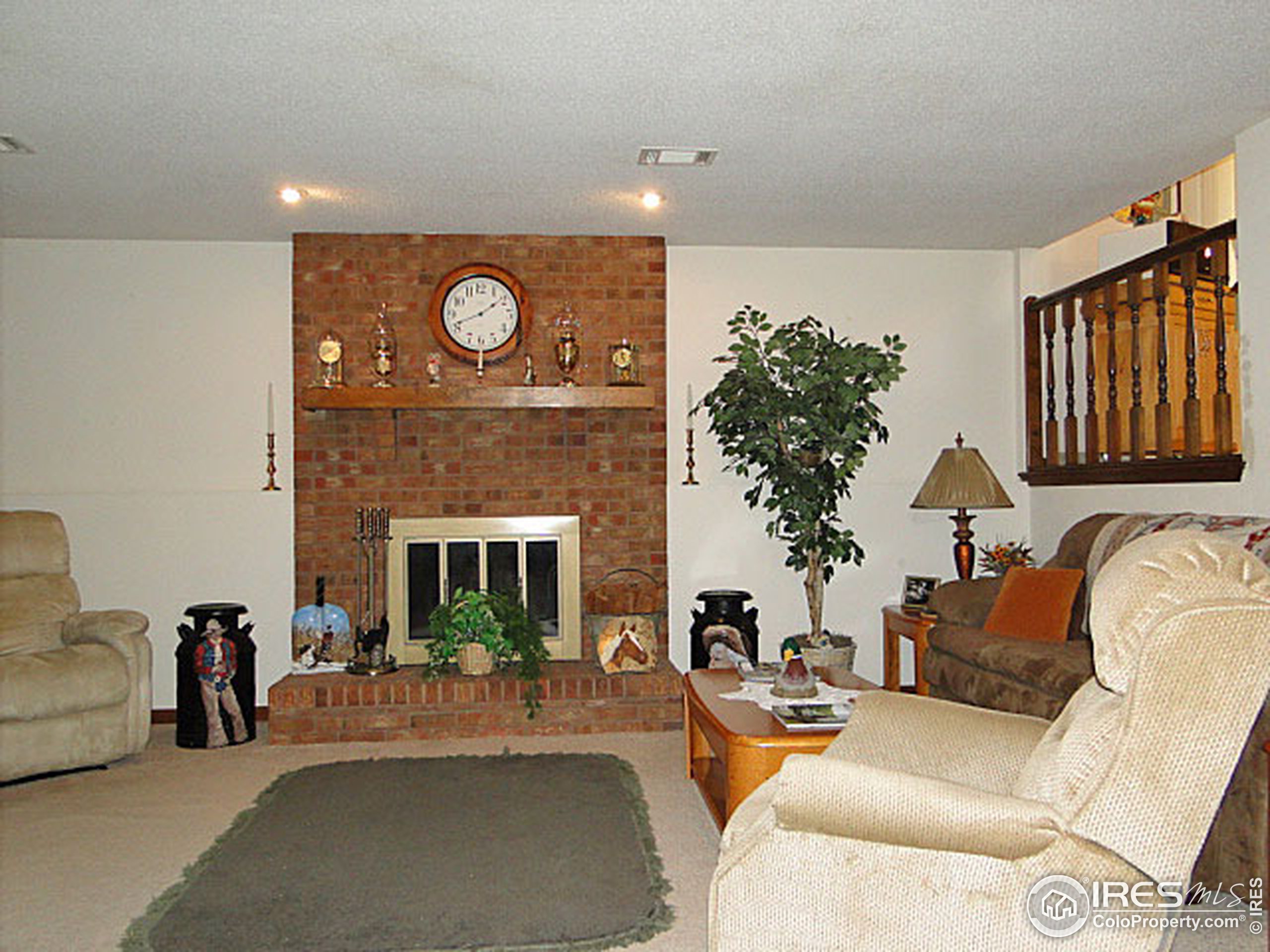 3334 34th Street Greeley, CO 80634 - Photo 16 of 25 a living room with furniture a fireplace and a potted plant