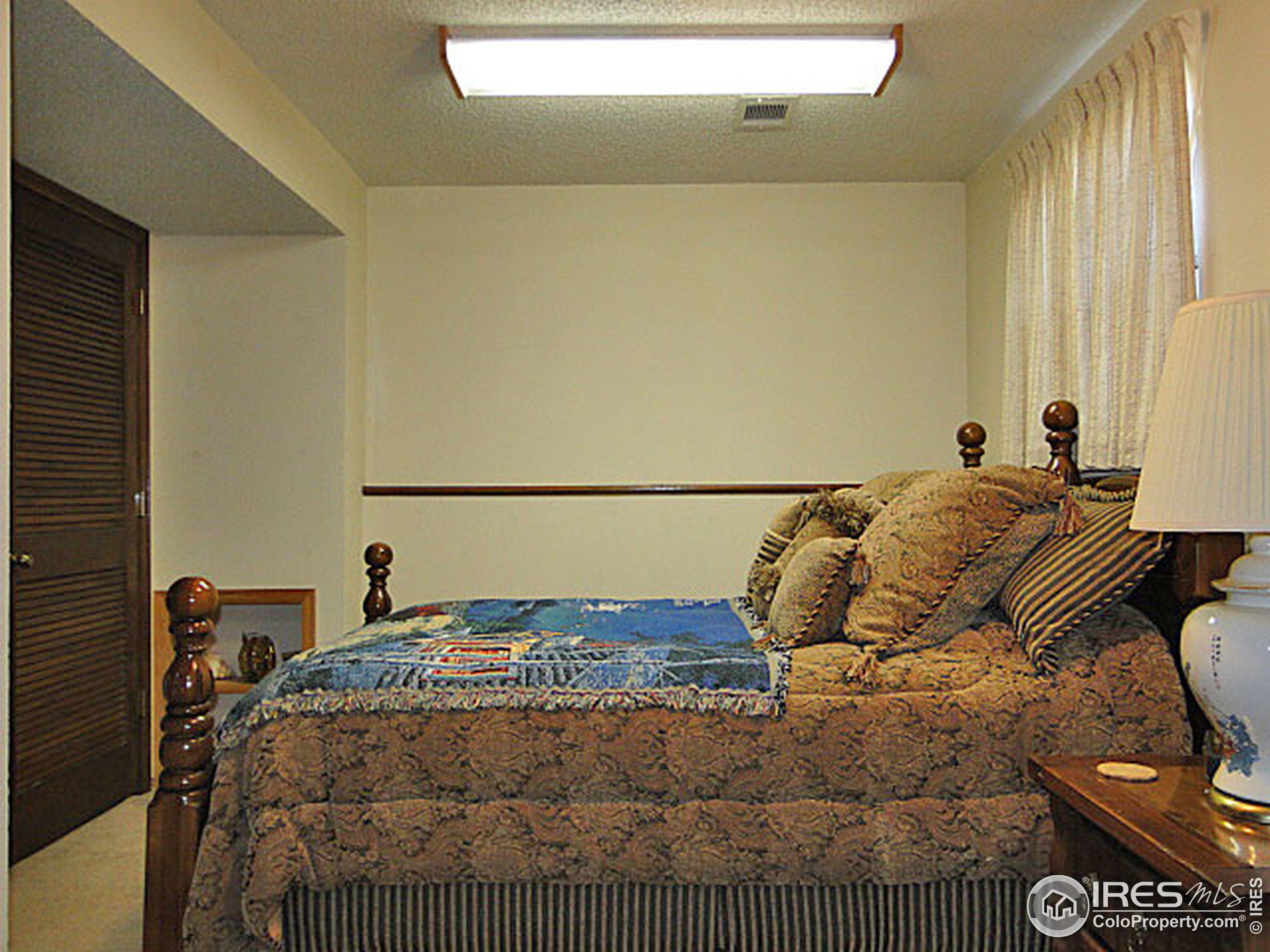 3334 34th Street Greeley, CO 80634 - Photo 18 of 25 a bedroom with a bed and wooden floor