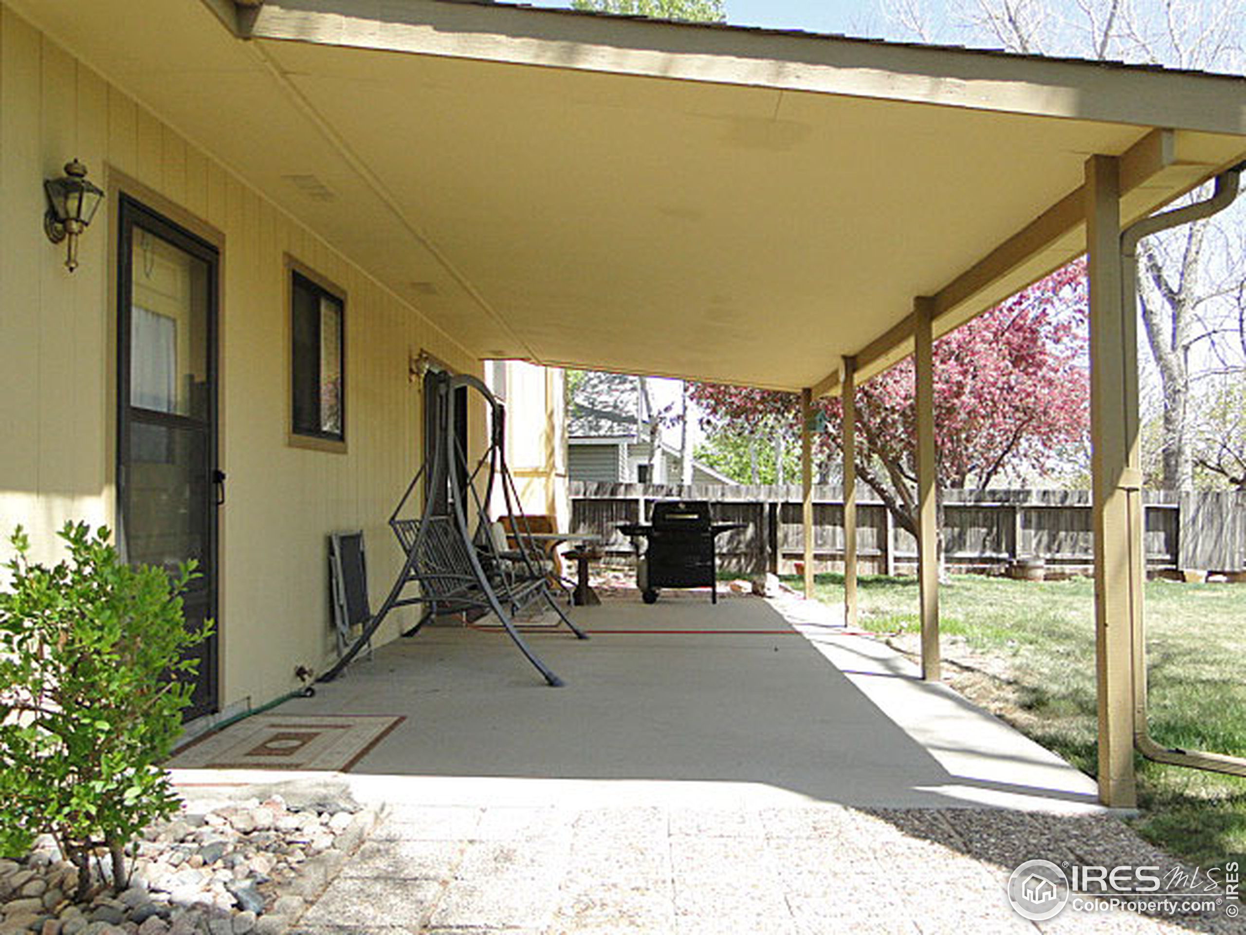 3334 34th Street Greeley, CO 80634 - Photo 23 of 25 a view of a patio with table and chairs potted plants with wooden floor and fence
